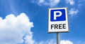 Free parking sign on a blue sky with clouds