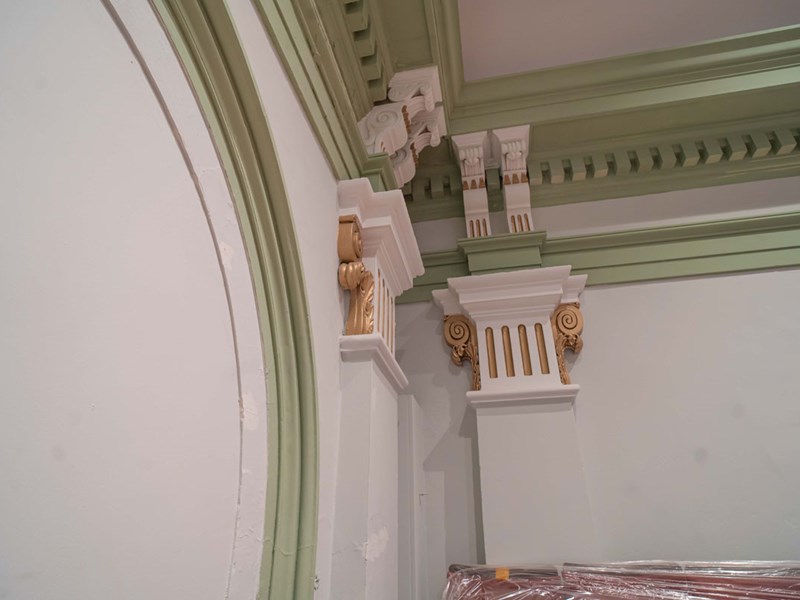 Restored original features within a ceiling, painted gold and green