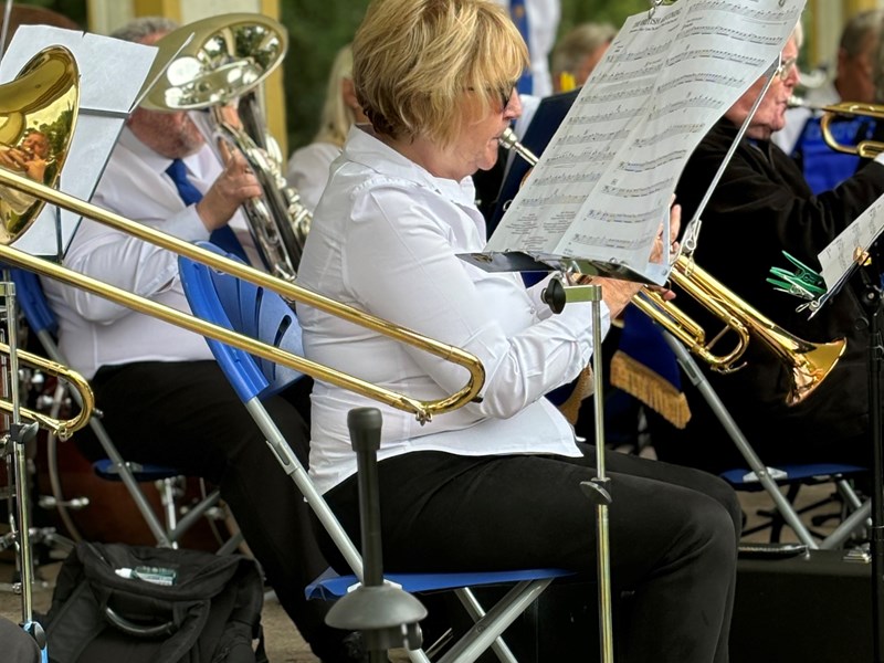 Close up image of some of the concert band members playing instruments in the bandstand.