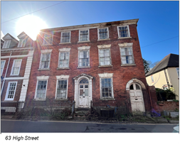 large rundown red brick mansion with many windows