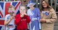 A woman and two children with Prince Harry and William masks stood next to Queen cutout