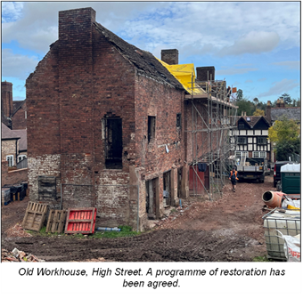 exterior of old large red brick building in a state of disrepair scaffolding erected on part of right hand wall