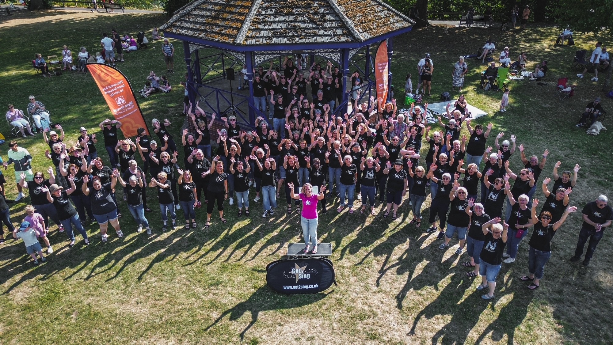 Aerial photo of the members of the Got to Sing choir standing on and in front of the bandstand at Stourport Riverside