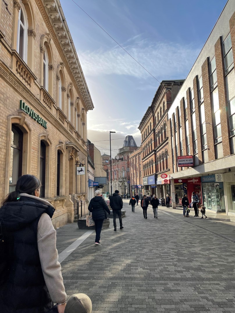 pedestrian street lined with tall brick buildings
