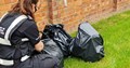 Officer with three black bags full of flytipping