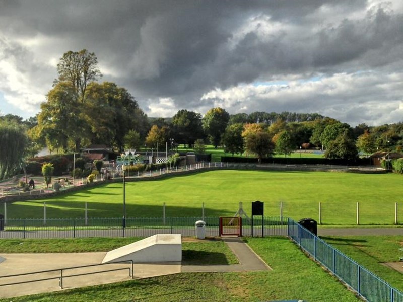 A putting grren and crazy golf located in the beautifully lawned park.