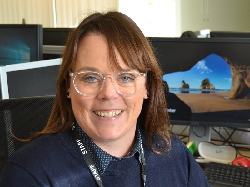 smiling woman sat at a desk
