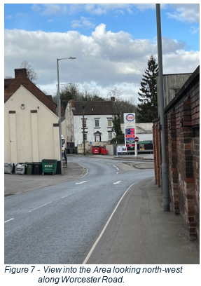 view along roadside to large painted buildings and petrol station