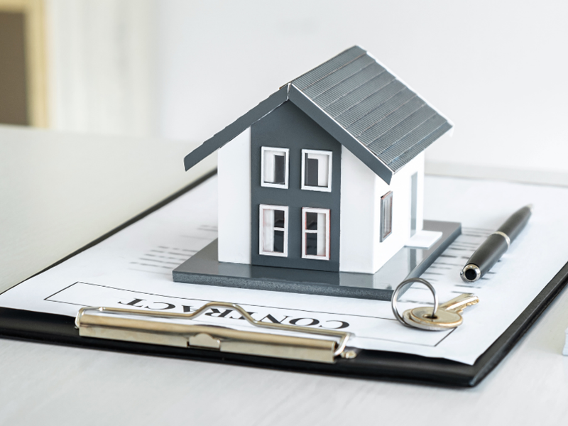 A small model house on top of a clipboard
