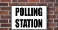 Polling station way in sign on a brick wall