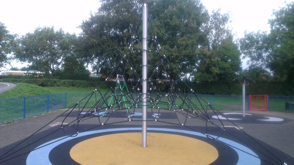 A climbing net within the children's play area and painted soft surface floor covering.
