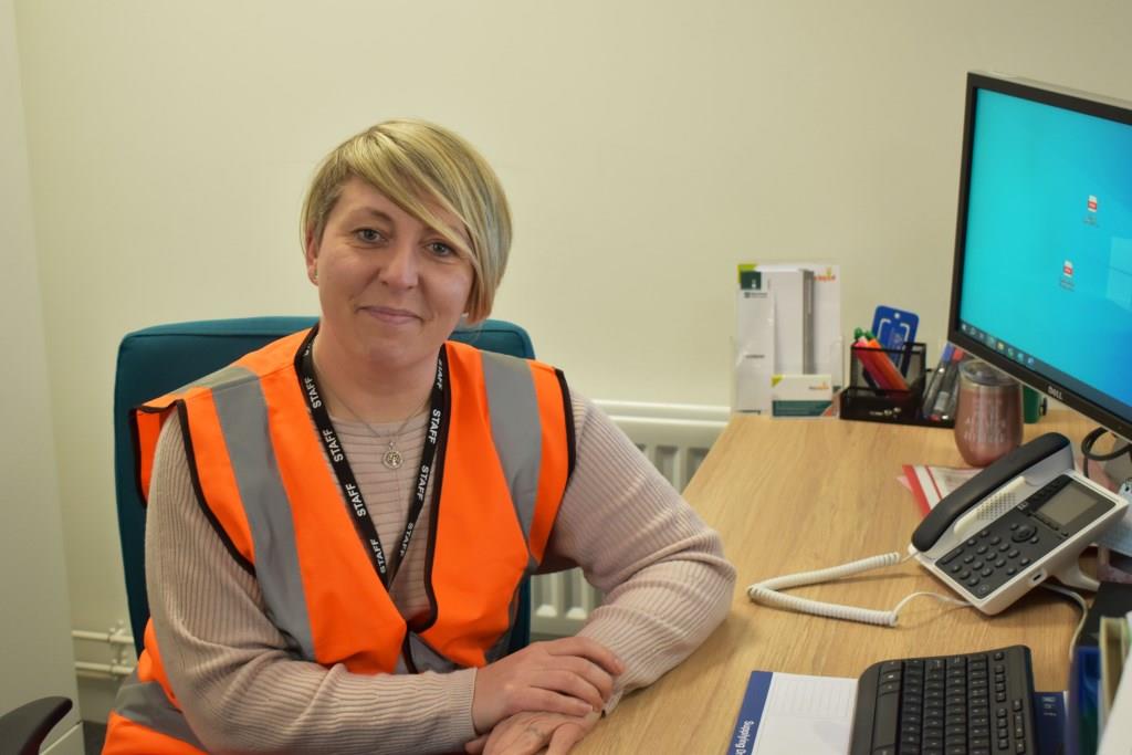 smiling woman sat at a desk