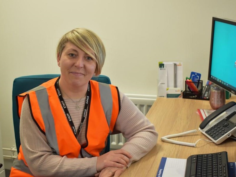 smiling woman sat at a desk