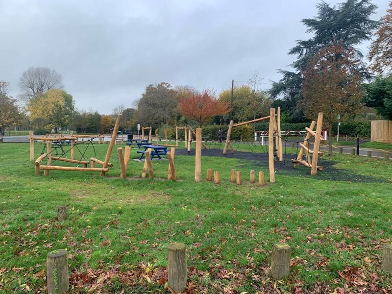 children's wooden adventure trail climbing structure in grassed area