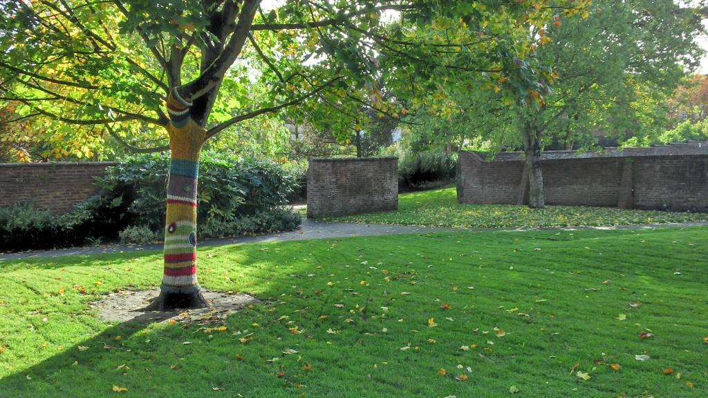 The gardens gateway back to the main high street, with high bricked pre-war walls, dotted across the grassed are mature trees guiding the way tot he gated exit of the gardens.