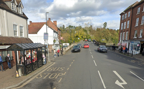view down road lined with shops trees in the background