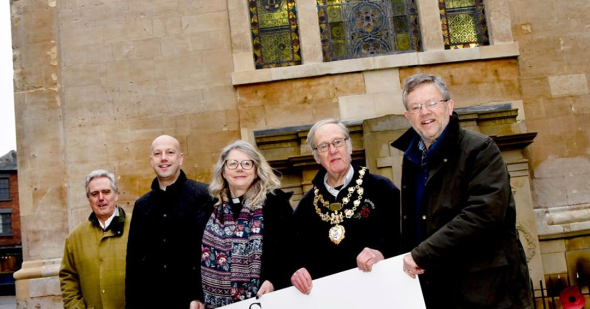 Five people stood in line with St Anne's Church in the background