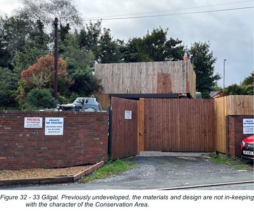 wooden clad building behind brick wall